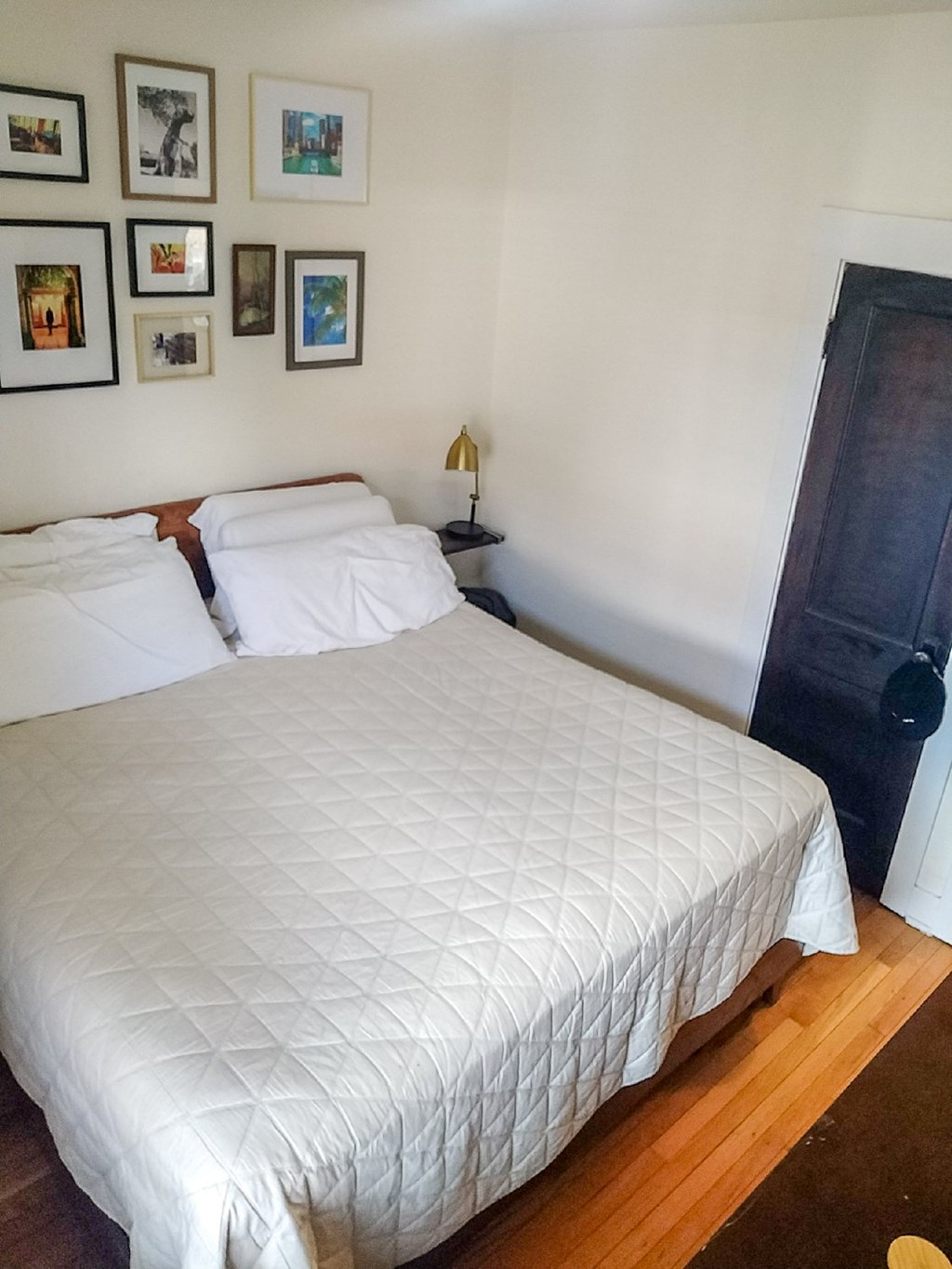 A white bed with a white comforter and two white pillows.