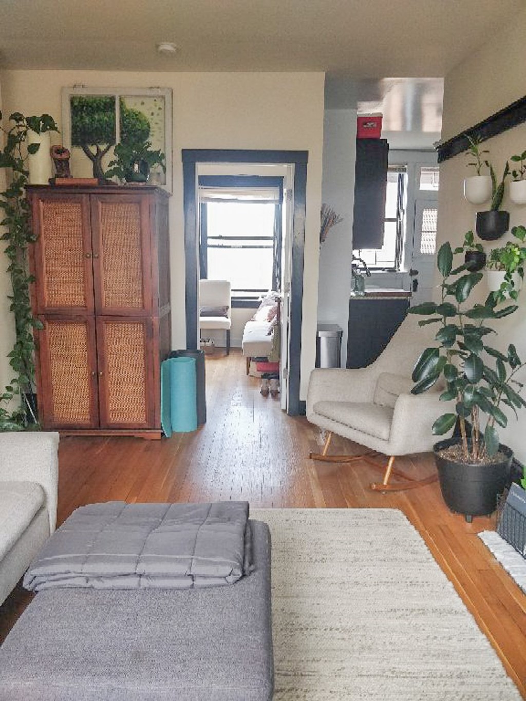 A living room with a grey rug and a wooden cabinet.
