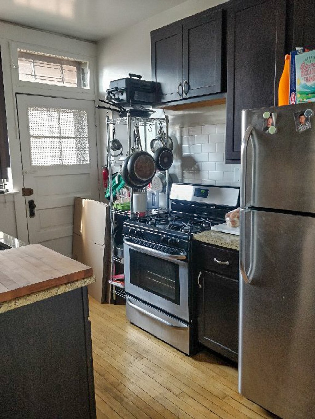 A kitchen with a stove top oven and a refrigerator.