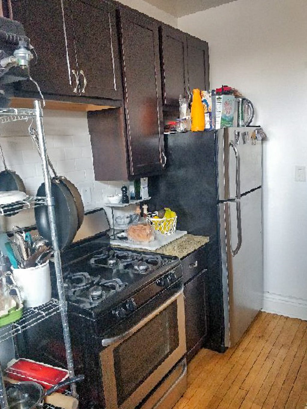 A kitchen with a black stove top oven and black refrigerator.