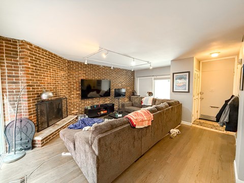 A living room with a couch, a fireplace, and a television.