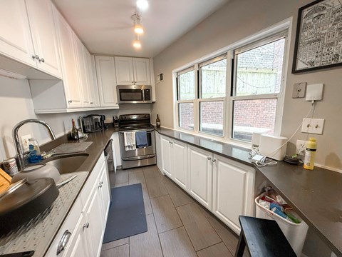 A kitchen with white cabinets and a black stove top.