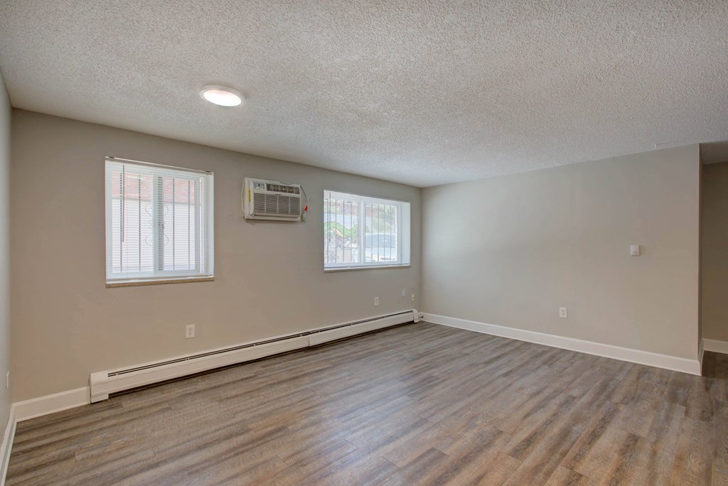an empty living room with hardwood floors and a window
