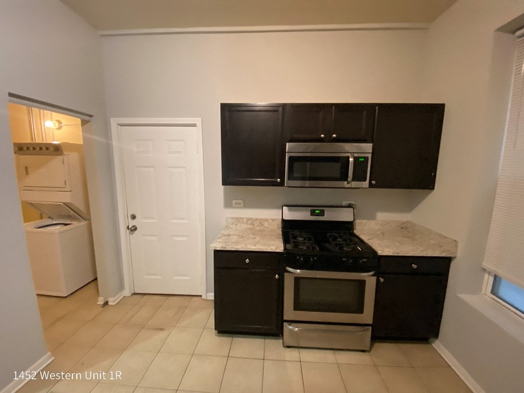 a kitchen with black cabinets and a white counter top