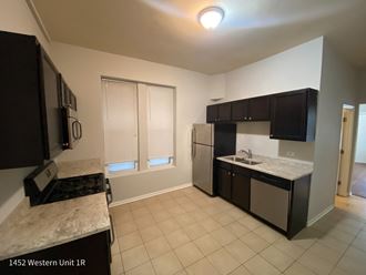 a kitchen with black cabinets and white countertops