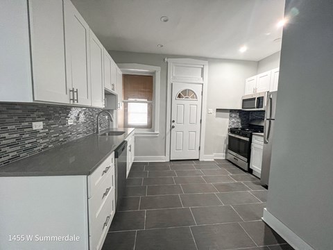 a kitchen with white cabinets and a white door