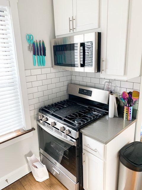 A kitchen with a stove and a microwave above it.