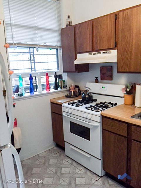 a kitchen with white appliances and wooden cabinets and a window