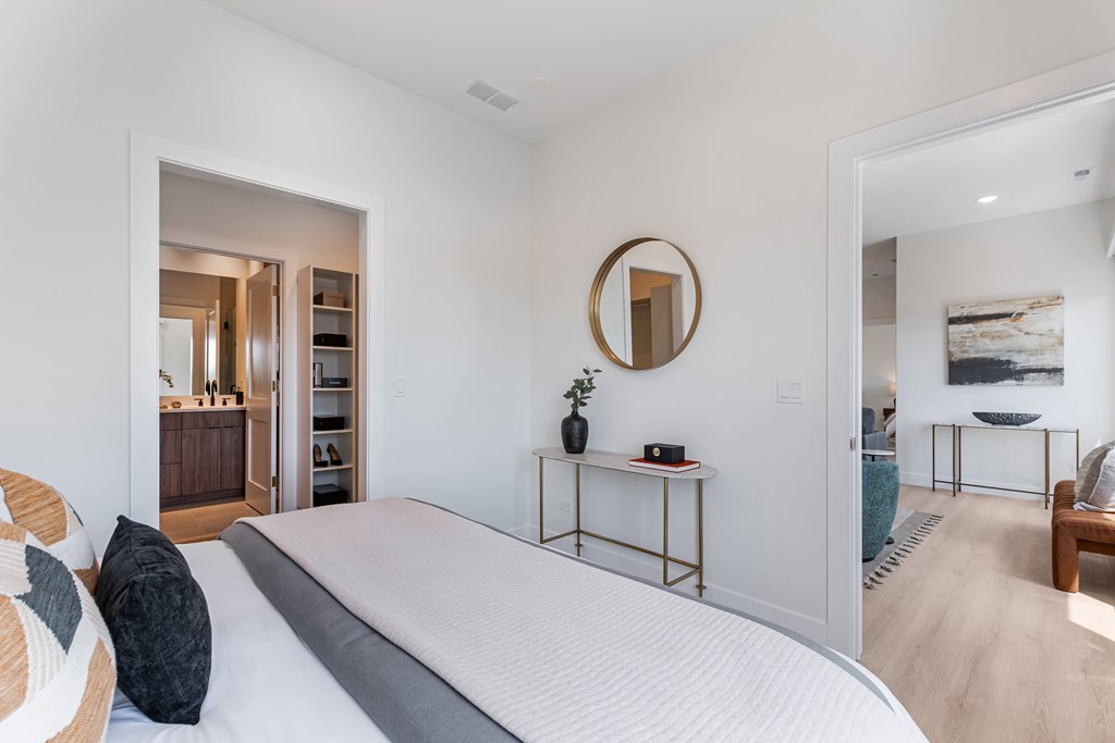 A bedroom with a large bed and a mirror on the wall.