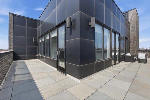 A modern building with a black facade and large glass windows.