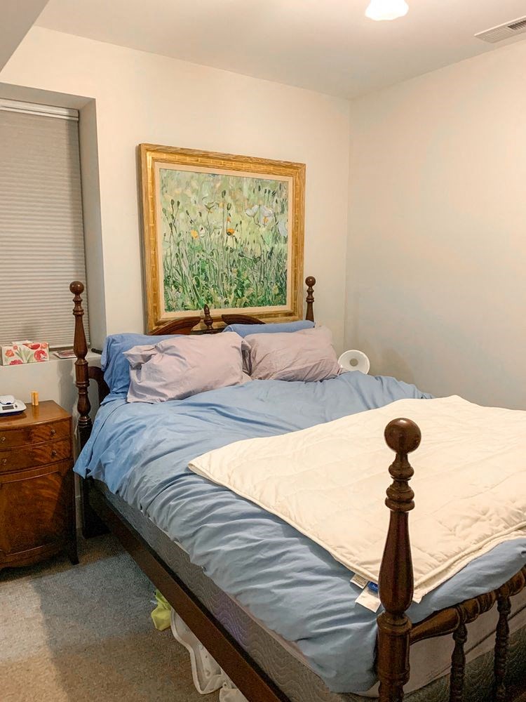 a bedroom with a bed and a painting on the wall