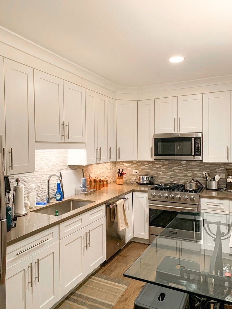 a kitchen with white cabinets and stainless steel appliances