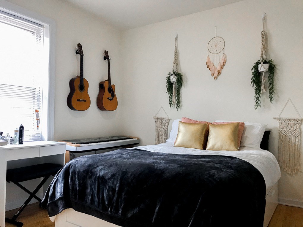 a bedroom with guitars on the wall and a bed