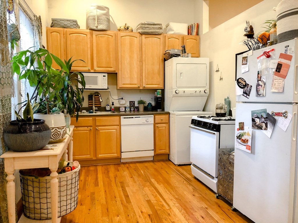 A kitchen with wooden cabinets and white appliances.