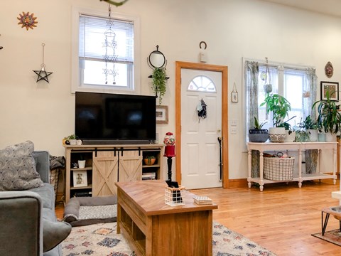 A living room with a grey couch, a wooden coffee table, and a television on a cabinet.