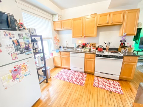 A kitchen with wooden floors and white appliances.