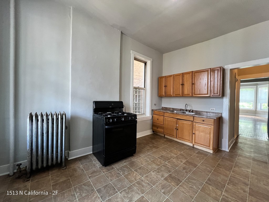 an empty kitchen with a stove and a sink