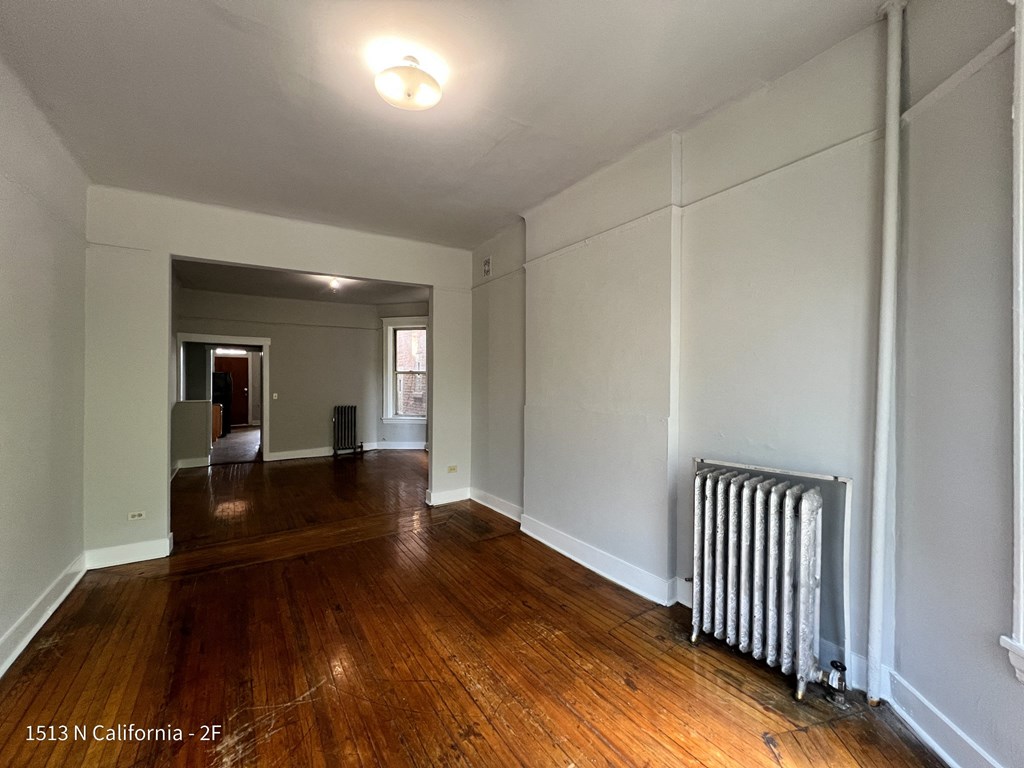 a living room with wood floors and a radiator