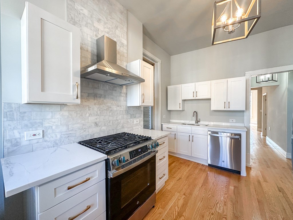 A kitchen with a white counter top and a black stove top oven.