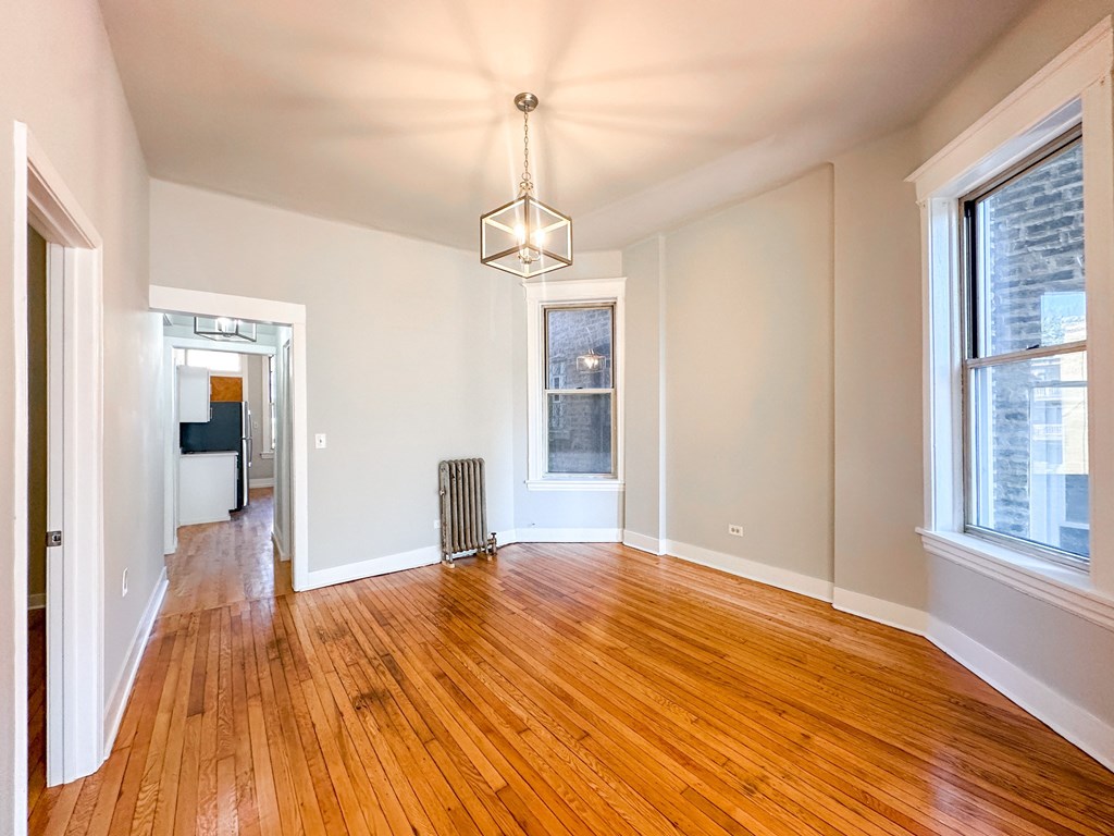 A room with wooden floors and a large window.