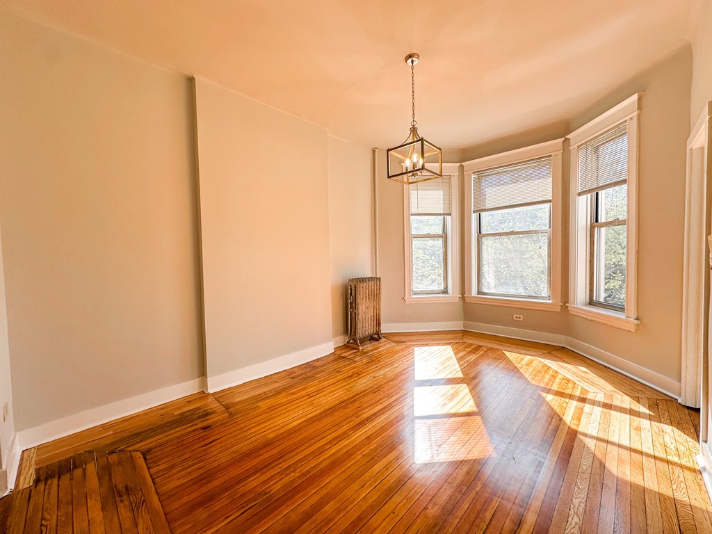A room with wooden floors and a radiator.