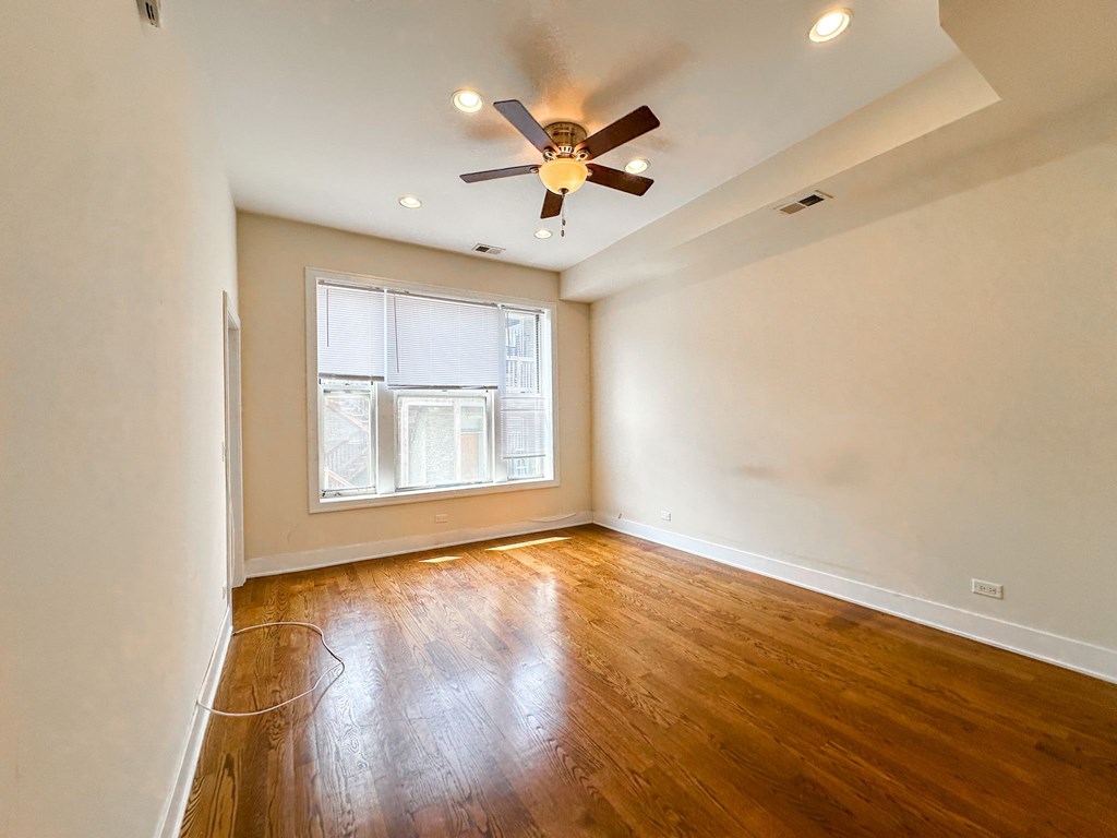 A room with a ceiling fan and a window.
