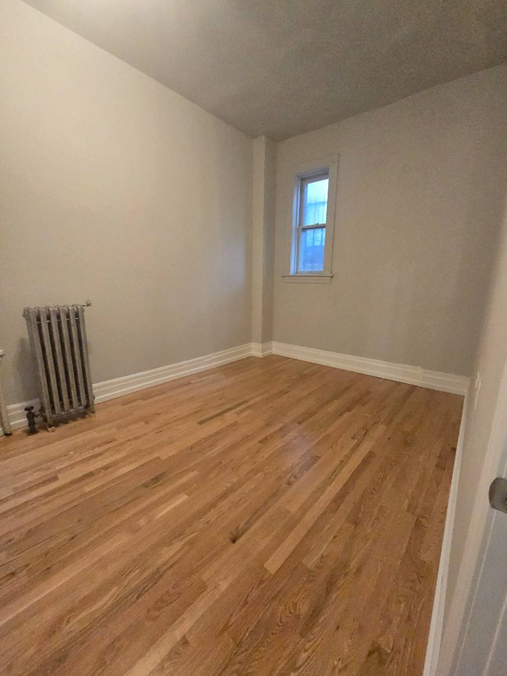 A room with wooden flooring and a window.