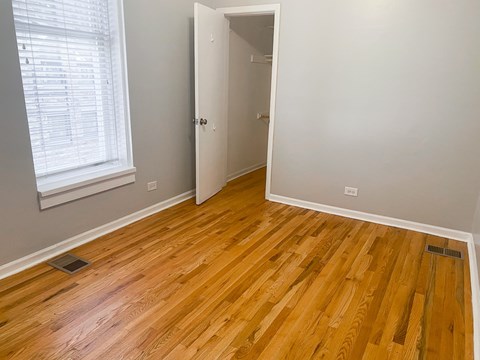 A room with a wooden floor and a white door.