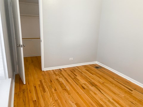 A room with a wooden floor and a white door.