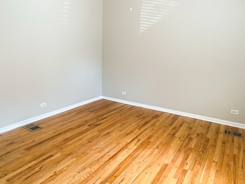 A room with wooden flooring and white walls.