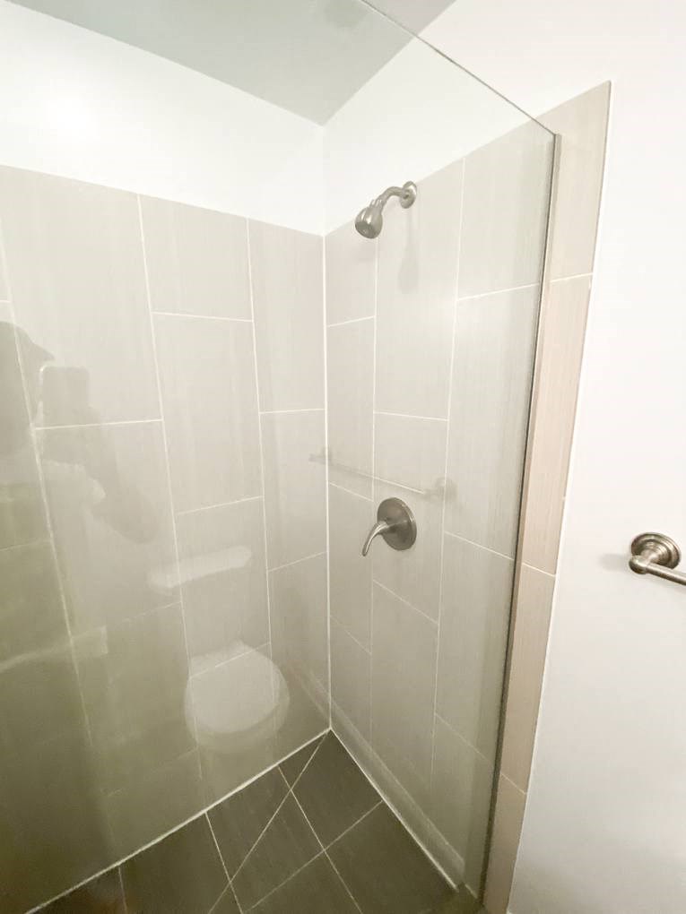 a white bathroom with a shower and a toilet