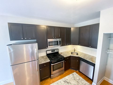 a kitchen with black cabinets and stainless steel appliances