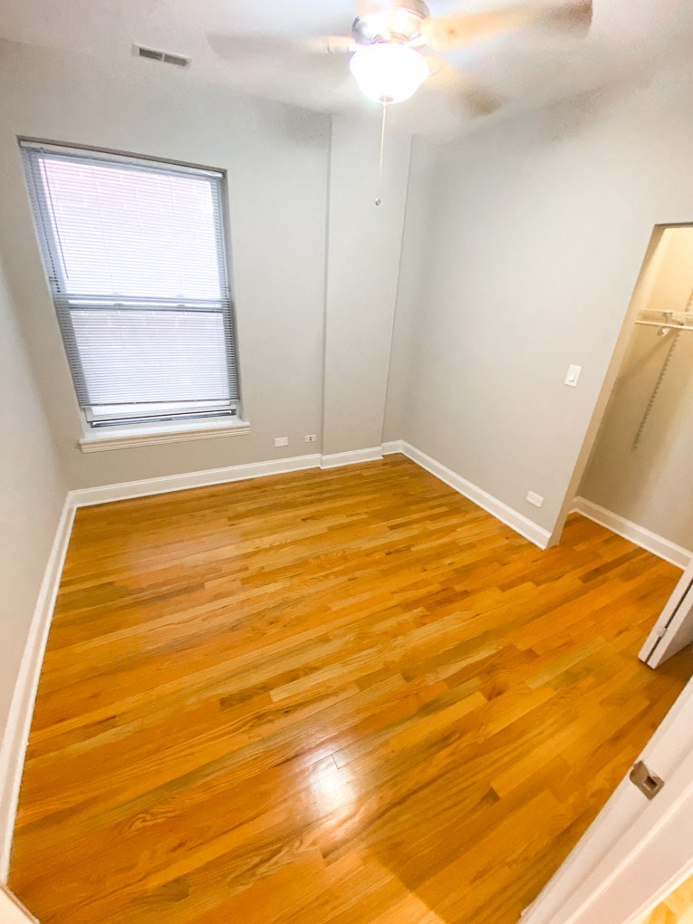 an empty room with wooden floors and a window