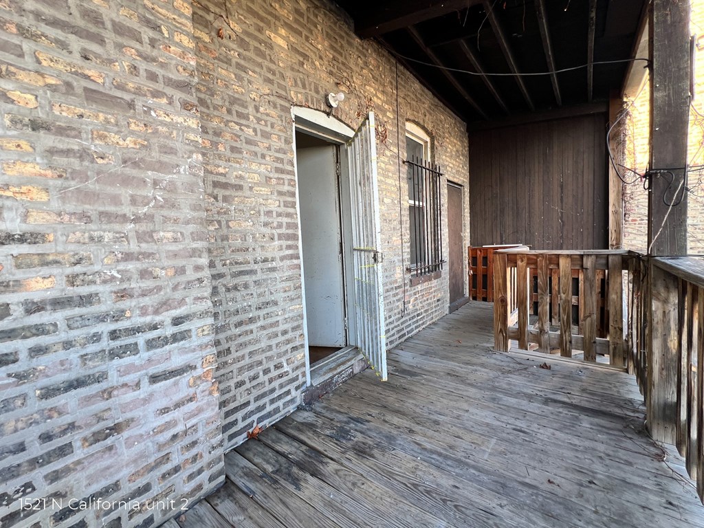 a porch with a door to a brick building