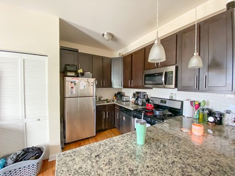 A kitchen with a granite counter top and stainless steel appliances.