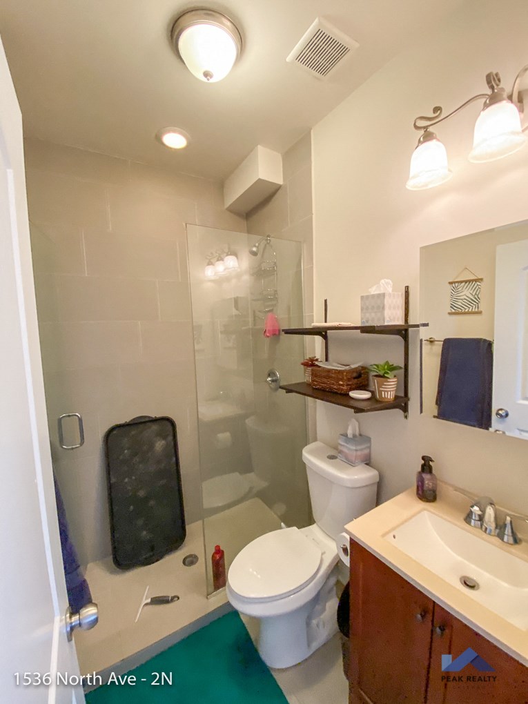 a small bathroom with a shower toilet and sink