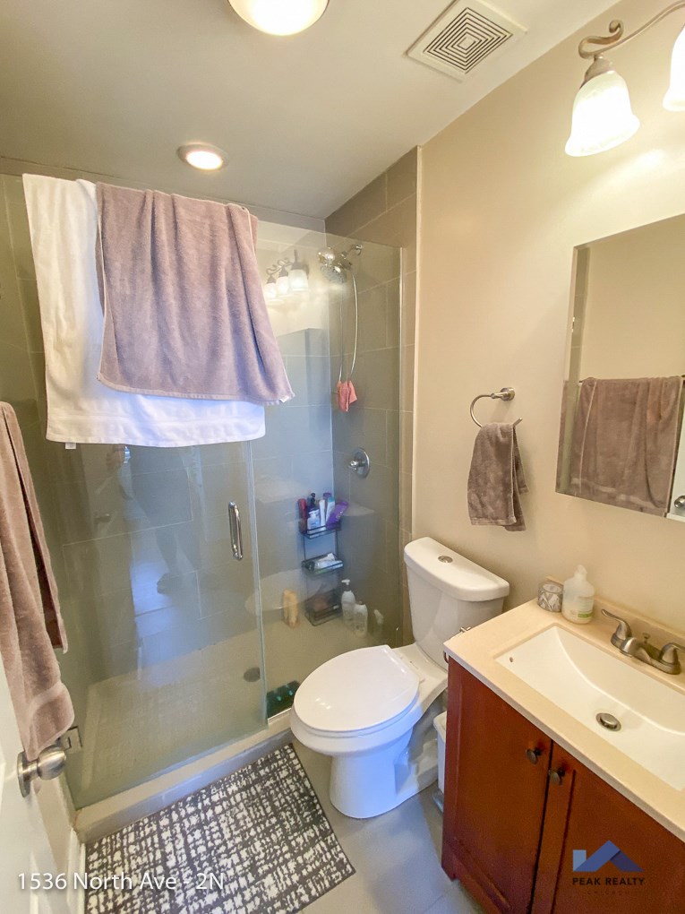 a small bathroom with a shower toilet and sink