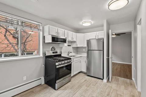 A kitchen with white cabinets and a black stove top oven.