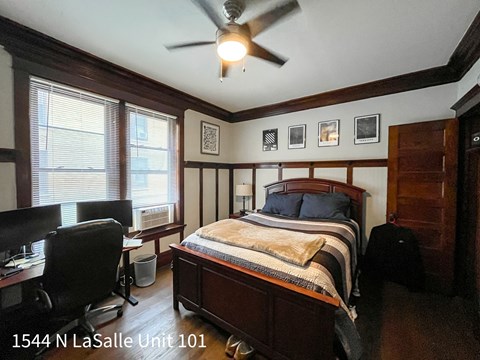 A bedroom with a bed, desk, and chair.