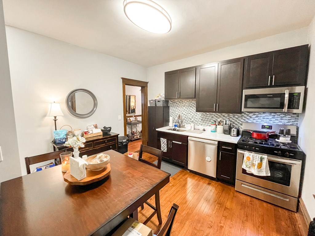 A kitchen with a wooden table and chairs.