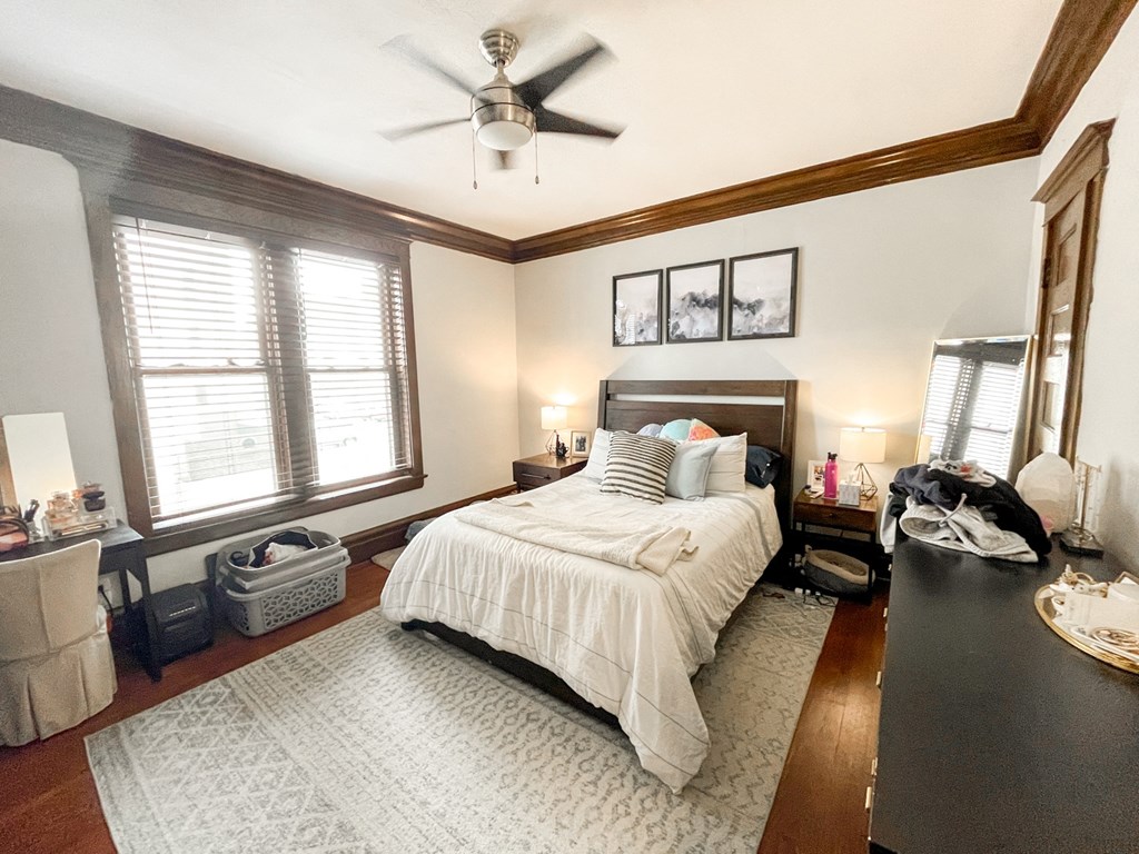 A bedroom with a large bed and a ceiling fan.