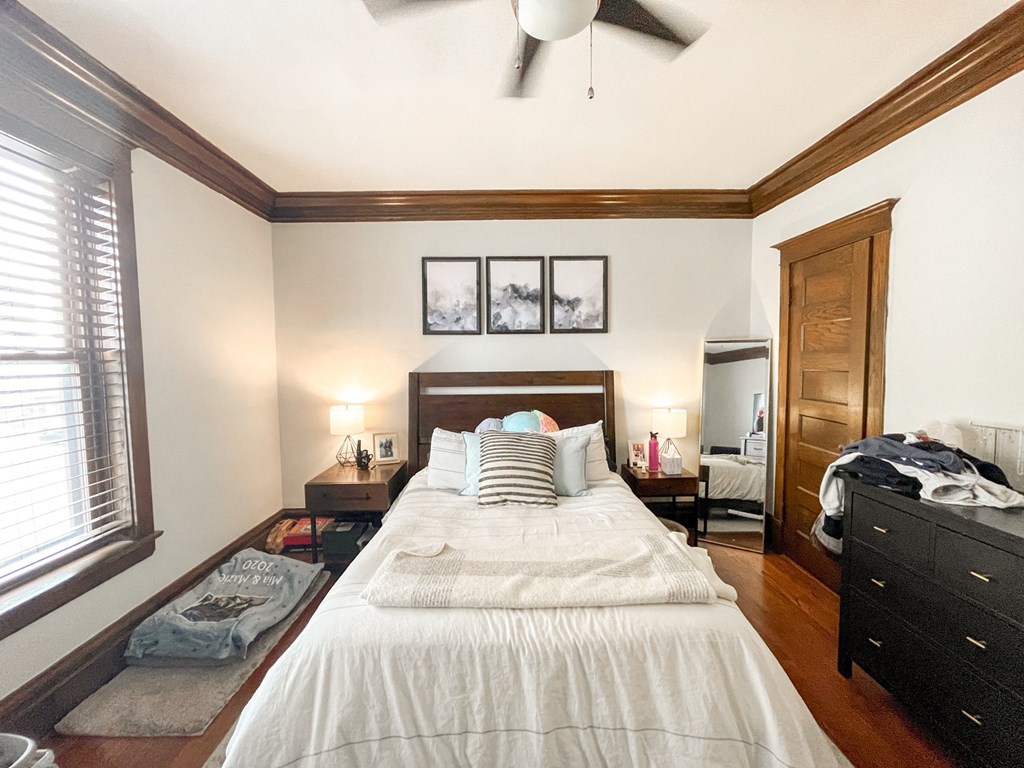 A bedroom with a large bed and a ceiling fan.