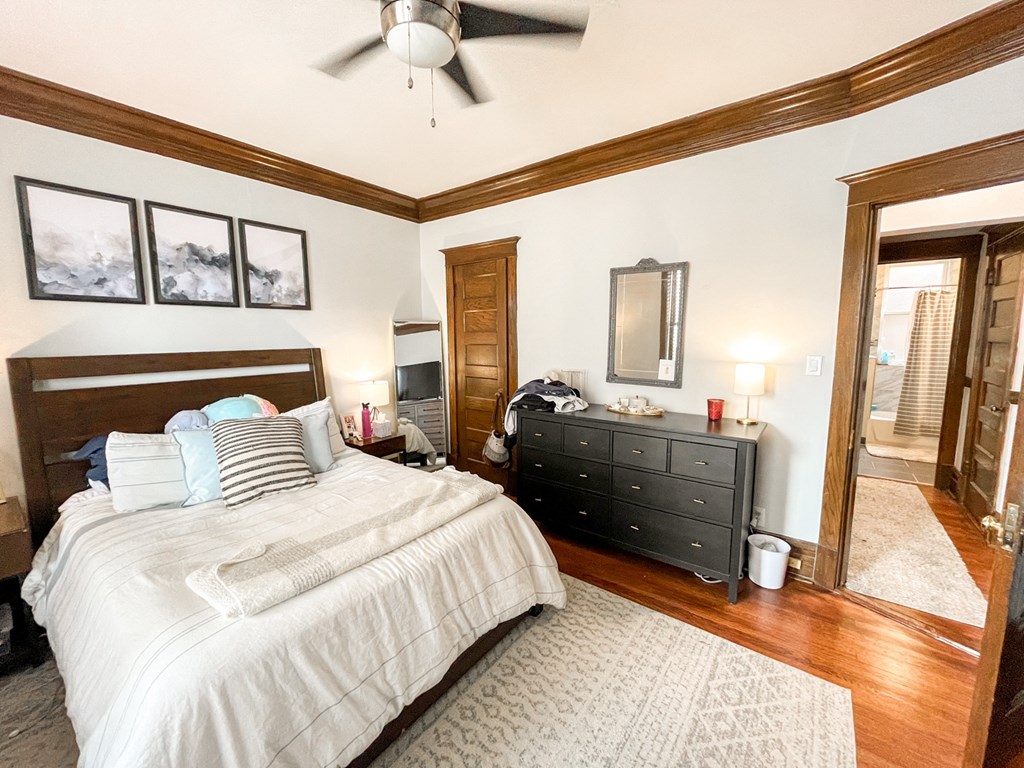 A bedroom with a large bed and a dresser.