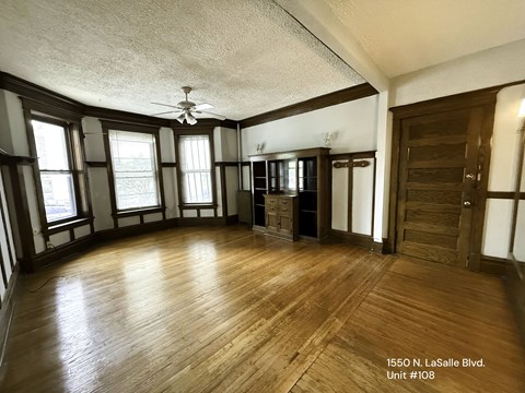 A room with wood floors and a ceiling fan.