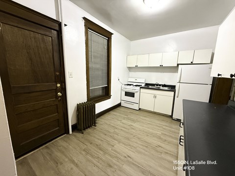 A kitchen with a black counter top and white cabinets.
