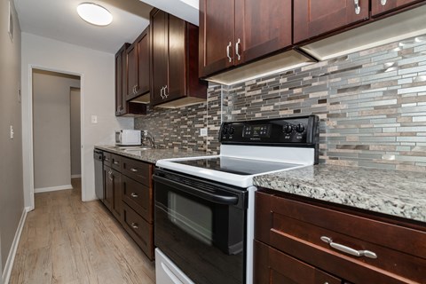 A kitchen with a black oven and a white stove.