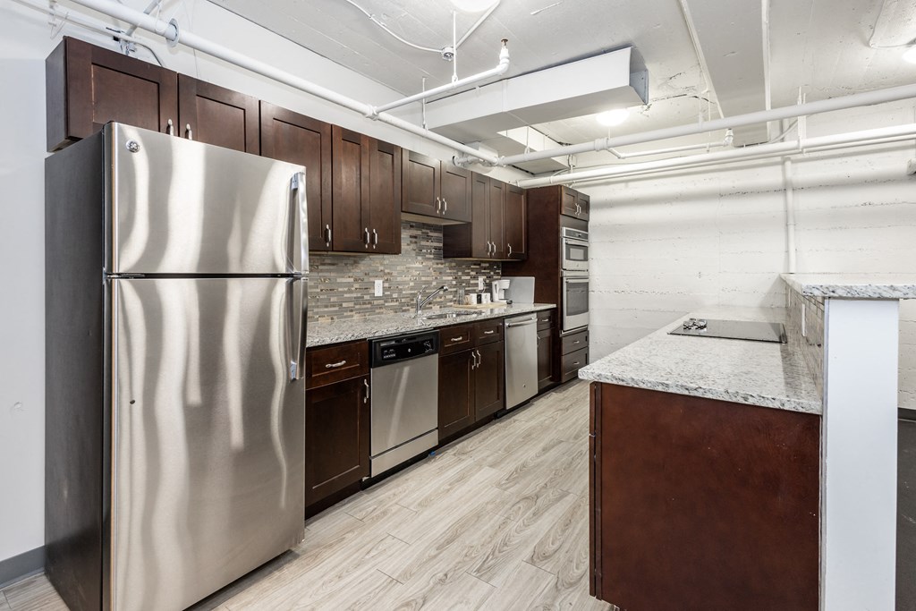 a kitchen with dark wood cabinets and white countertops