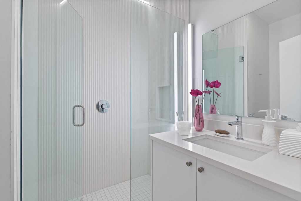 a bathroom with a shower and a sink and a mirror