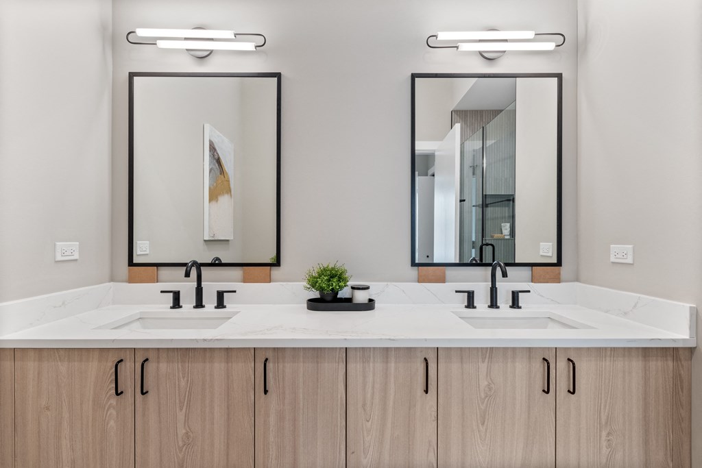 a bathroom with two sinks and two mirrors