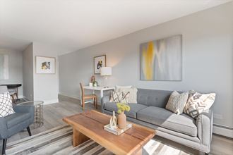a living room with a gray couch and a wooden coffee table